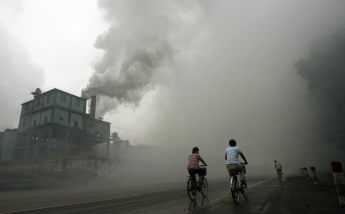 Cyclists pass through thick pollution fr